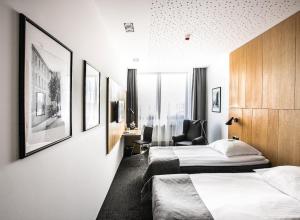 een hotelkamer met 2 bedden en een stoel bij Hotel Olimp Business & Spa in Wejherowo