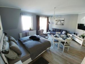 a living room with a bed and a dining room at Apartamenty Aleksandria in Kamień Pomorski
