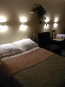 ミコワイキにあるApartament Słoneczna 3のベッド2台、椅子、照明が備わるホテルルームです。