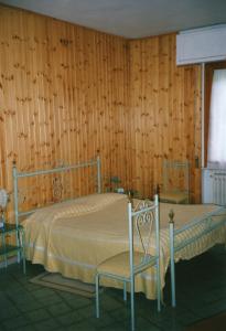 2 camas en una habitación con paredes de madera en Albergo Padellino en Vaglia