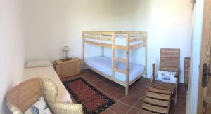 1 dormitorio con 2 literas y 1 silla en Casa Eden beach, en Sorso