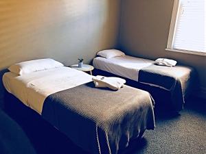 a room with three beds with towels on them at Swansea Hotel in Swansea