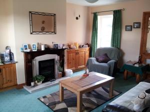 un soggiorno con tavolo e camino di Ashfield B&B a Kenmare