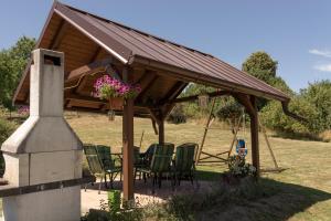 a wooden pavilion with chairs and a table in a field at Roubenka Doubravice in Hrubá Skála