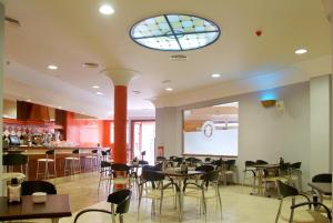 een restaurant met tafels en stoelen en een raam bij Hostal Carmen in Zafra