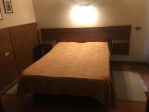 a bed in a room with a light on the wall at Pension Roma in Cairo