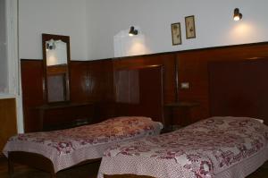 a hotel room with two beds and a mirror at Pension Roma in Cairo