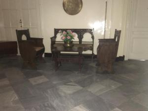 a room with a piano and chairs and a vase of flowers at Pension Roma in Cairo