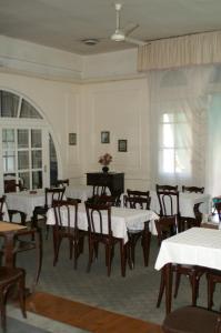 a dining room with tables and chairs and a piano at Pension Roma in Cairo