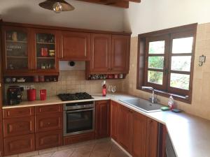 Villa for rent in MILIOU close to Lachi & Peyia في ميليو: مطبخ بدولاب خشبي ومغسلة