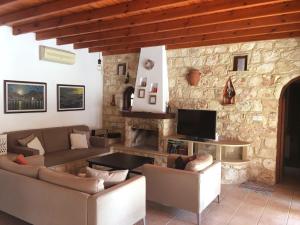 Villa for rent in MILIOU close to Lachi & Peyia في ميليو: غرفة معيشة مع أريكة ومدفأة