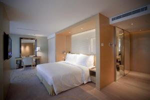a bedroom with a large white bed and a desk at City Viva Hotel Macau-Fomerly Hotel Million Dragon Macau in Macau