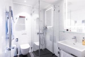 a bathroom with a shower and a toilet and a sink at Sorell Hotel Rüden in Schaffhausen