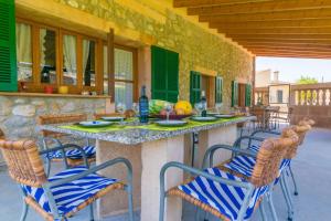 patio con tavolo e sedie sotto il portico di CANTABOU SA COMA D'INCA a Moscari