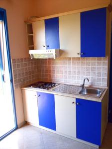 una cocina con armarios azules y blancos y fregadero en Eleart en Golem