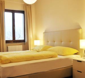 1 dormitorio con 1 cama blanca grande y ventana en Gardenmaisonette, en Malcesine