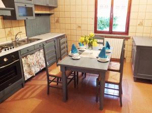 cocina con mesa con sillas y fregadero en Gardenmaisonette, en Malcesine