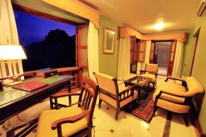 a room with a desk and chairs and a window at Palace Hotel - Bikaner House in Mount Ābu