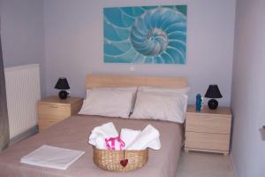 a bedroom with a bed with a basket of towels at Christina's House in Iraklitsa