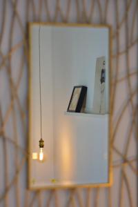 un miroir mural avec une lumière dans la chambre dans l'établissement Pension Casa Pinilla, à Cascante