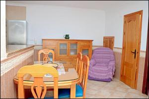 コニル・デ・ラ・フロンテーラにあるApartamento Conil Ceutaのキッチン(テーブル、椅子、ベッド付)