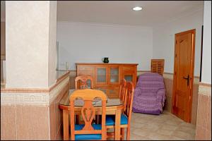 コニル・デ・ラ・フロンテーラにあるApartamento Conil Ceutaのキッチン(テーブル、椅子、ベッド付)