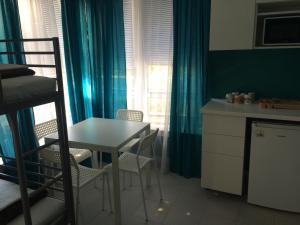 a small room with a table and chairs and a kitchen at Guesthouse JANA in Pomorie