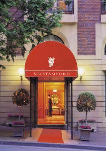 a man walking into the entrance to a st regis hotel at Sir Stamford Circular Quay in Sydney