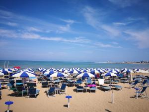 a bunch of chairs and umbrellas on a beach at Hotel Boutique Il Castellino Relais in Vieste