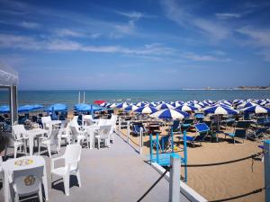 a bunch of chairs and umbrellas on a beach at Hotel Boutique Il Castellino Relais in Vieste