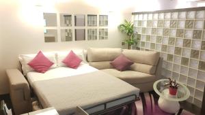 a living room with a white couch with pink pillows at Domus Paradiso City Center in Rome