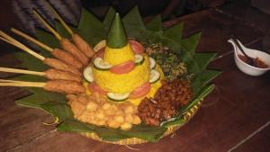 a plate of food with a fruit and vegetables on a table at Rosseno Villa in Yogyakarta