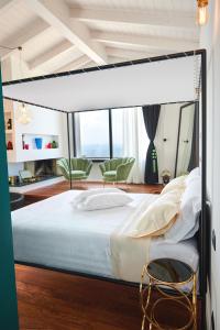 Idea 18 Boutique Hotel في Controguerra: غرفة نوم بسرير كبير وكرسيين