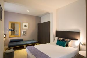 a hotel room with a bed and a bench at LeMar by Aspasios in Barcelona