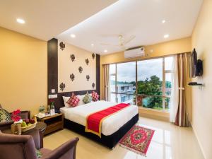 a hotel room with a bed and a window at Central Courtyard Boutique Hotel in Siliguri