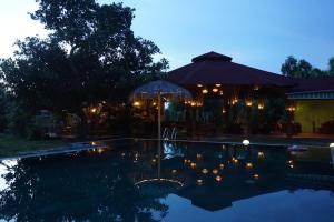 a swimming pool at night with an umbrella at Ninila Fruit Farm Bungalow in Phú Quốc