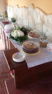 a table with cakes and plates on a counter at Casale Del Borgo in Hermada