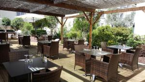 un restaurant avec des tables et des chaises sur une terrasse dans l'établissement Hôtel New Palmarium, à Amélie-les-Bains-Palalda