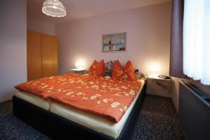 クリンゲンタールにあるFerienhaus Körnerのベッドルーム1室(大型ベッド1台、オレンジ色の掛け布団付)