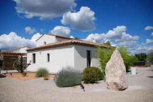 a white house with a large rock in front of it at Villa Otilia-Bed and Breakfast-Chambres d'hôtes en Provence in Rians