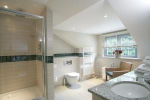 a bathroom with a shower and a toilet and a sink at Rothay Garden Hotel & Riverside Spa in Grasmere