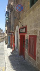 a building with a red door and a sign on it at Ivory Suite Valletta in Valletta
