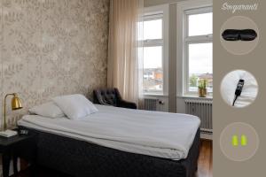 a bedroom with a bed with a chair and a window at Grand Hotel Jönköping in Jönköping