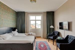 una camera da letto con un letto, due sedie e una finestra di Grand Hotel Jonkoping, BW Signature Collection a Jönköping