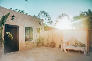 a patio with a bed and a table with plants at Hotel Anilevich Mansion in Beer Sheva