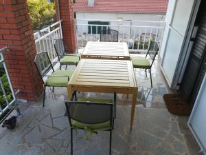 a wooden table and chairs on a balcony at Apartmani Parlov in Vinišće