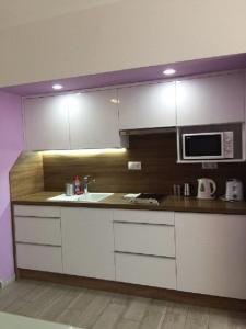 cocina con fregadero y microondas en ALOE Apartman, en Sárvár