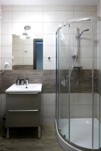 コウォブジェクにあるCHILLIapartamenty - Bliżej Morza - SMILEのバスルーム(ガラス張りのシャワー、シンク付)