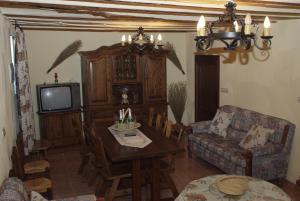 sala de estar con mesa y TV en Casa Rural La Liebre en Hinojares