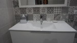 a bathroom with a white sink and a mirror at L'appollu in La Porta